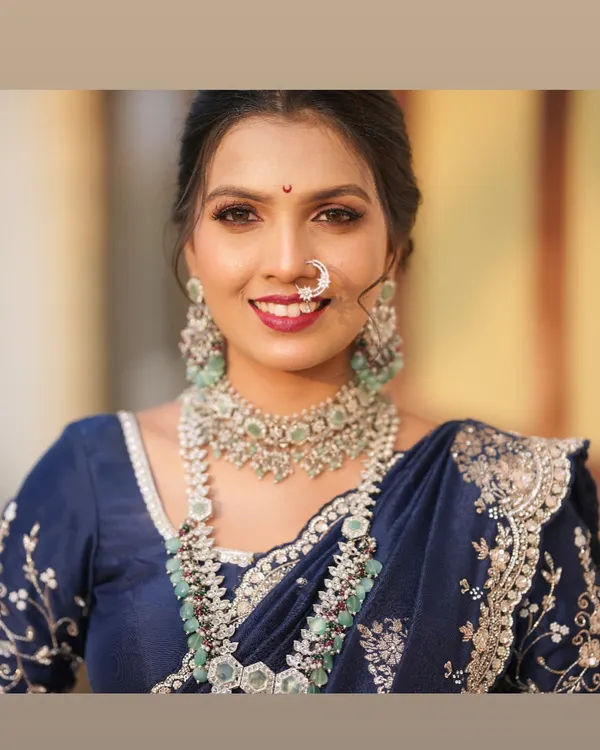 A close-up of this bride's radiant smile is what my work is all about. I focused on a bold lip and defined eyes to complement her stunning blue and silver reception saree and intricate diamond jewellery.