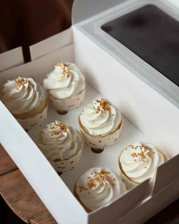 A box of my classic vanilla cupcakes. Sometimes simple is best. These are topped with creamy vanilla bean frosting and a sprinkle of gold sugar.