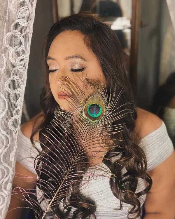 A creative and artistic shot from a portfolio session. The peacock feather adds a touch of mystique to this soft glam makeup look.
