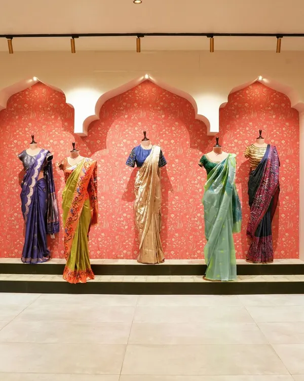 The main display wall at the 'House of Vaarasa' store. We used traditional Indian arched niches against a textured pink wall to create a stunning backdrop for the handloom sarees, making the products the heroes of the space.