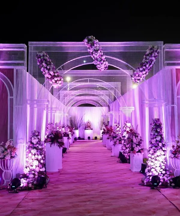 I designed this stunning floral tunnel to give guests a truly grand entrance. The combination of purple uplighting, white framework, and dense floral arrangements created a dramatic and immersive walkway, setting a luxurious tone for the wedding reception.