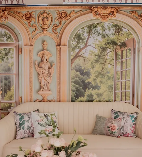 A romantic seating area from our 'Mint to Be' event. A plush cream sofa is set against a backdrop of painted French-style windows and arches, creating the illusion of being in a beautiful European garden pavilion.
