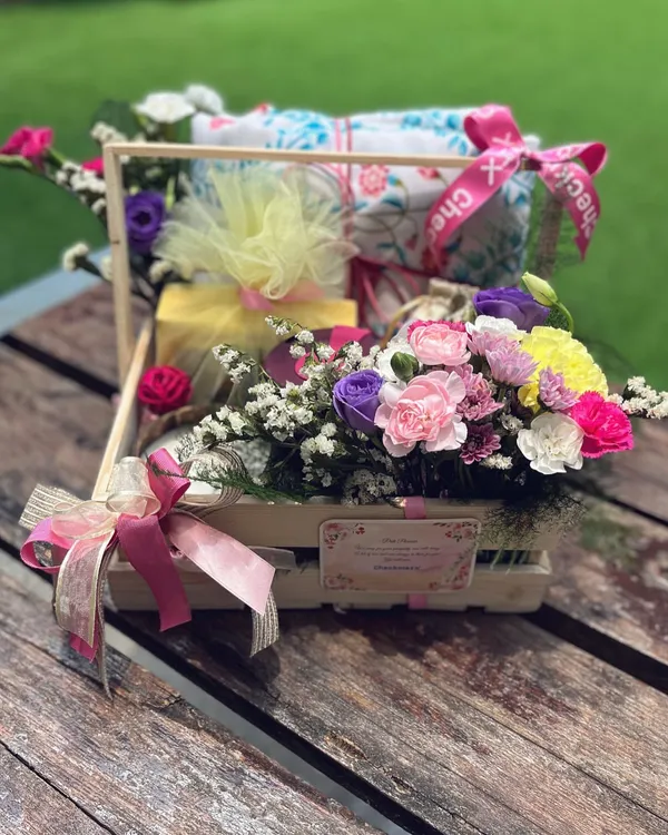 A "Get Well, Beautifully" hamper, designed to bring comfort and cheer. This pine basket is filled with soft textiles, soothing treats, and a vibrant bouquet of fresh flowers to brighten their recovery.