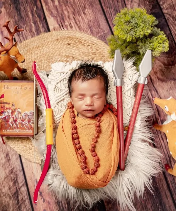 A tribute to the epic Ramayana, this unique setup features a newborn dressed as a young sage, complete with a rudraksha necklace. The scene is adorned with a bow, arrows, and deer, evoking a sense of ancient adventure.