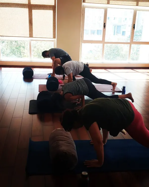A shot of students fully engaged during an arm balance workshop at the Svadhyaya studio in Powai. Everyone is focused on their own mat, but the collective energy is strong.