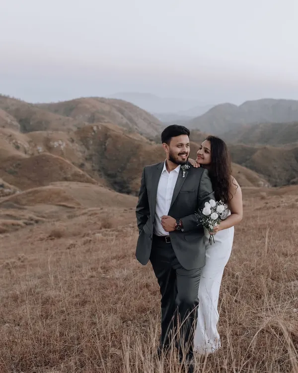 A stunning portrait set against the rolling hills. The couple's classic attire contrasts beautifully with the wild, untamed landscape, creating a timeless and romantic image.