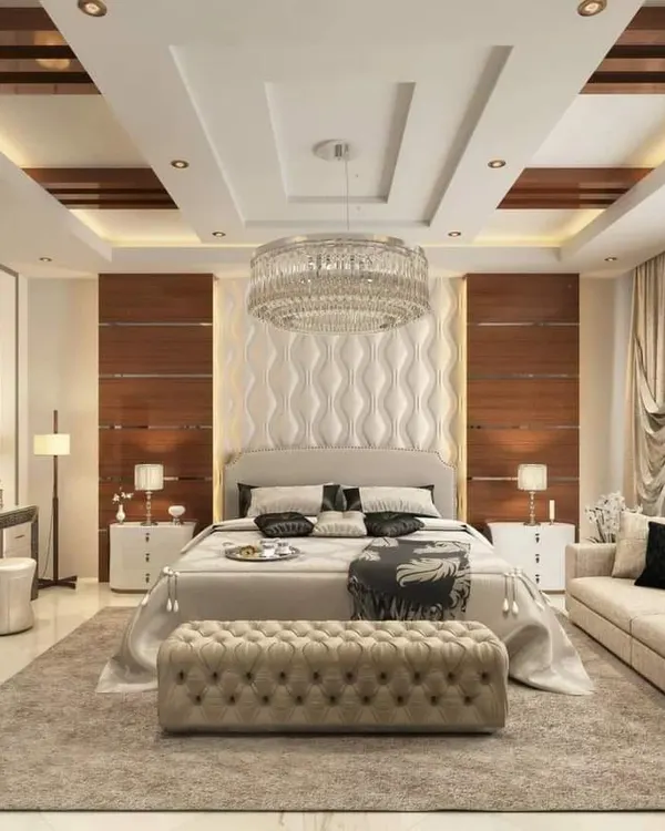 This is a truly luxurious master bedroom suite. I designed it with a stunning crystal chandelier, a custom upholstered headboard with 3D wave panels, and a separate seating area, creating a five-star hotel feel at home.