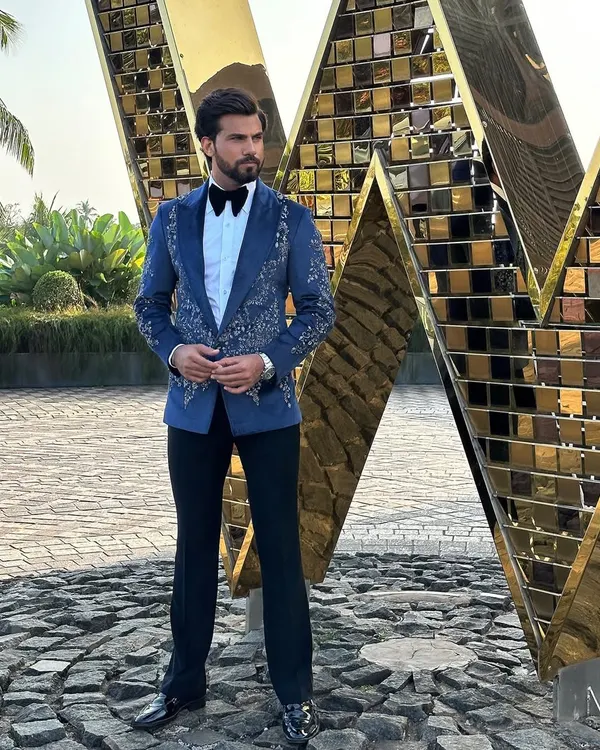 A full-length view of our hand-embroidered Nacre Tuxedo. This piece is designed to command attention, combining traditional black-tie elements with bespoke artistry for a truly unique wedding or event look.