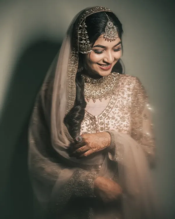 A moment of quiet reflection. This bride's gentle smile and the soft, warm lighting create a timeless and elegant portrait.