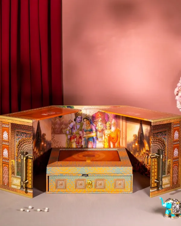 This is a truly divine invitation box that opens up to reveal a sacred scene. It is designed as a small temple or 'mandir', creating a deeply spiritual and memorable unboxing experience for a wedding announcement.