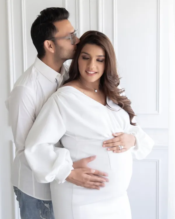 A tender moment from an all-white maternity session. I guide couples into poses that feel natural and loving, capturing the quiet intimacy before the baby arrives.