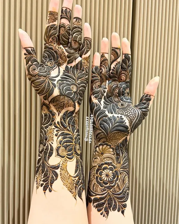 This is my signature style. I love creating these full, dense floral patterns that cover the entire hand and arm. The contrast between the bold, dark-filled flowers and the delicate, lighter details is what I aim for in my Gulf-inspired henna art.
