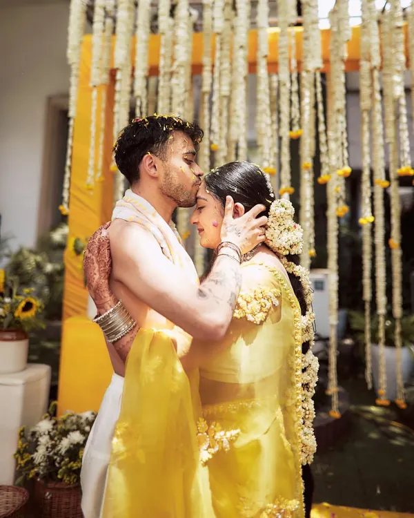 An intimate and emotional moment between the couple during their Haldi ceremony. The backdrop of hanging jasmine and marigold strings provides a traditional and fragrant setting for these beautiful memories.