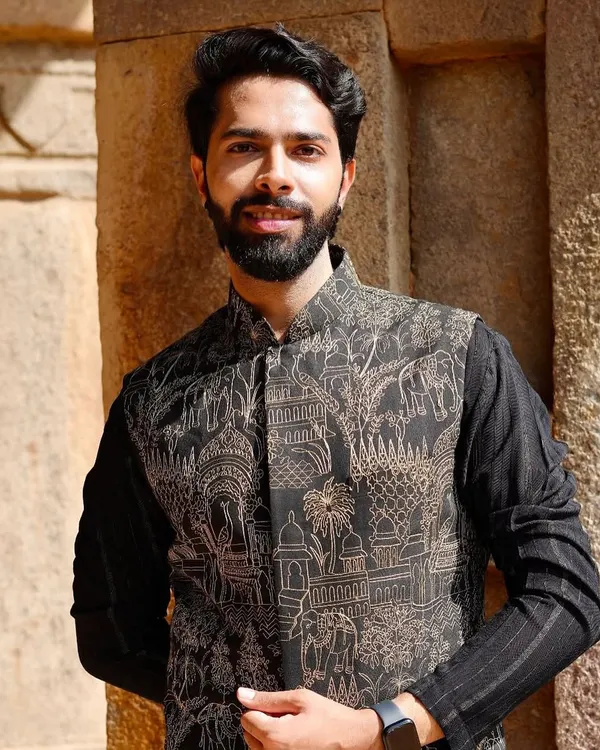 A modern interpretation of traditional thread work. This black Nehru jacket features intricate prints inspired by Indian architecture and motifs, layered over a classic black kurta.