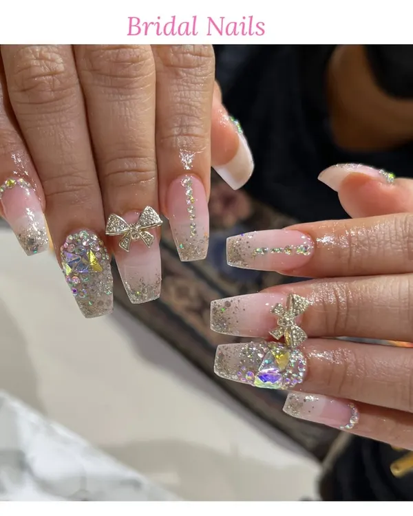 A perfect example of our detailed bridal nail service. This set includes long square extensions with a glitter ombre, 3D bows, and carefully placed rhinestones to match any wedding dress.