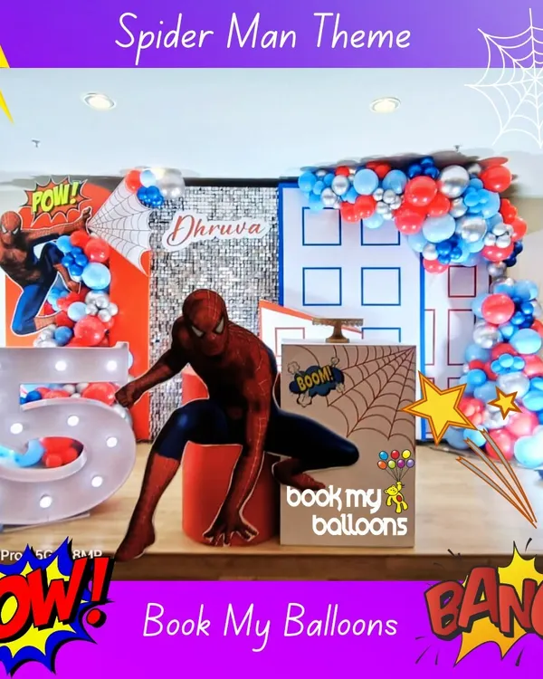 Your friendly neighborhood Spider-Man swings in to save the party. This setup for Dhruva's 5th birthday features a city backdrop, comic book-style props, and a large light-up number '5' that Spidey is perched on.