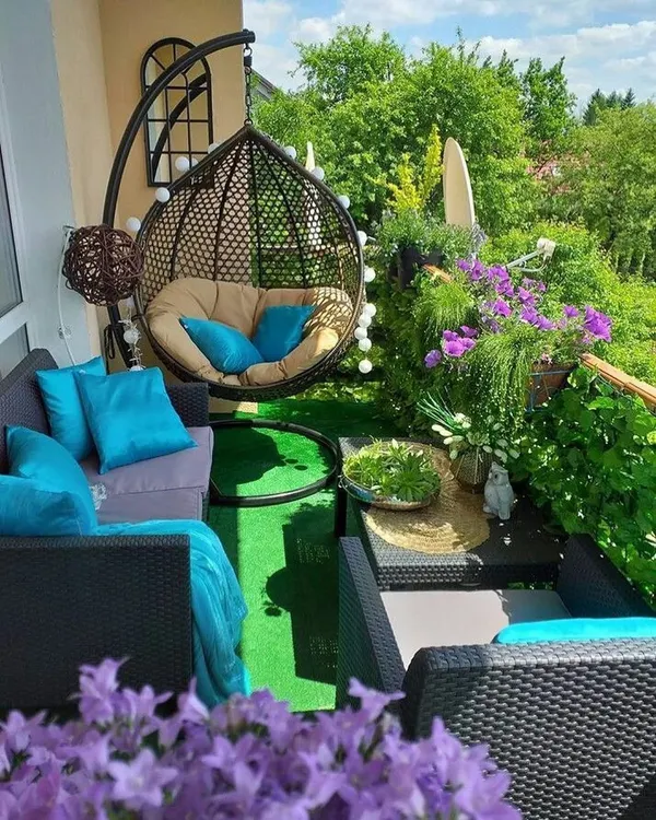 A perfect example of a cozy and vibrant balcony garden. We used a mix of comfortable seating, a hanging swing chair, and an abundance of flowering plants to create a lush, colorful escape.