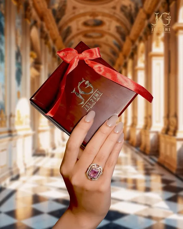 The feeling of pure luxury. This image captures the moment of receiving a special gift, with a stunning pink gemstone ring on hand, ready to be treasured. The perfect gift for an unforgettable presence.