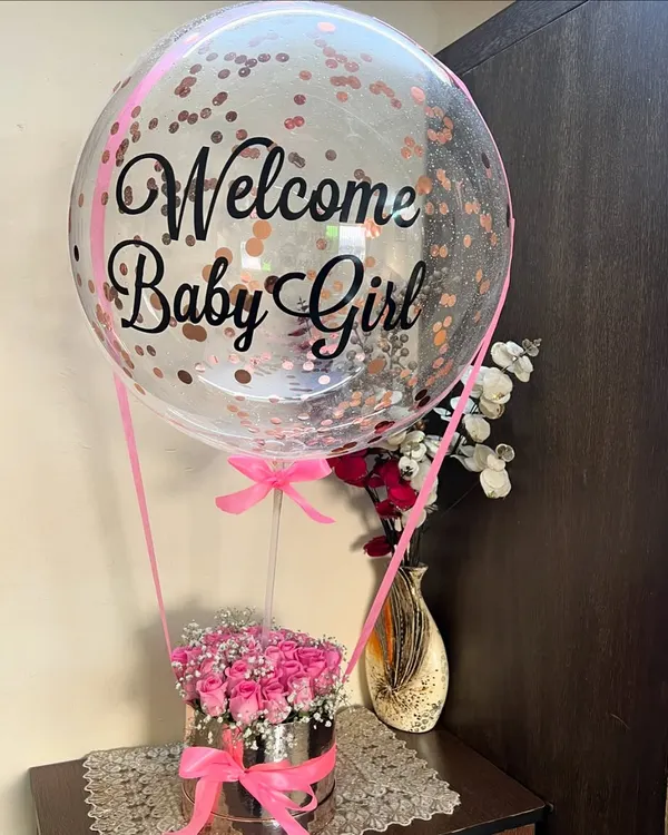 Our signature hot air balloon floral arrangement is the cutest way to say 'Welcome Baby Girl'. We fill a luxe silver box with fresh pink roses and baby's breath, then top it with a custom confetti balloon to make the celebration extra special.