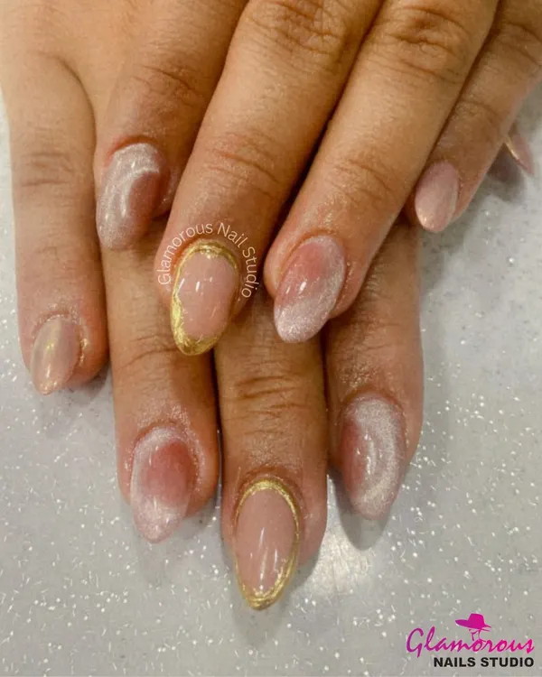 The epitome of elegance. This minimalist design features a sheer nude base with a soft, white ombre effect and a delicate gold chrome outline on the accent nails.