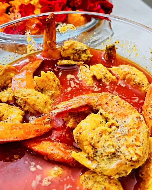 A close-up of my signature Shorshe Chingri. These are juicy prawns cooked in a pungent, flavourful mustard gravy, a true Bengali delicacy that I prepare using a secret family ingredient. It's a must-have for any authentic Bengali feast.