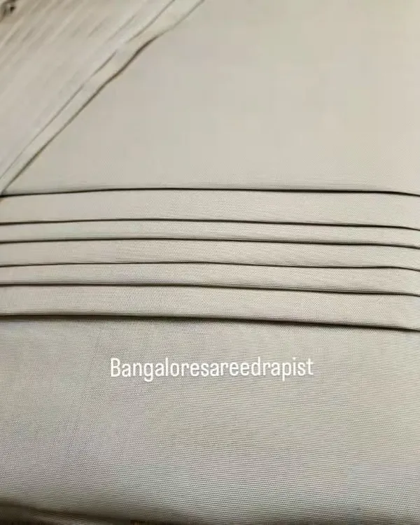 A close-up of the neat lines on a box-folded engagement saree. This compact fold protects the delicate fabric and ensures the pleats remain crisp during transport.