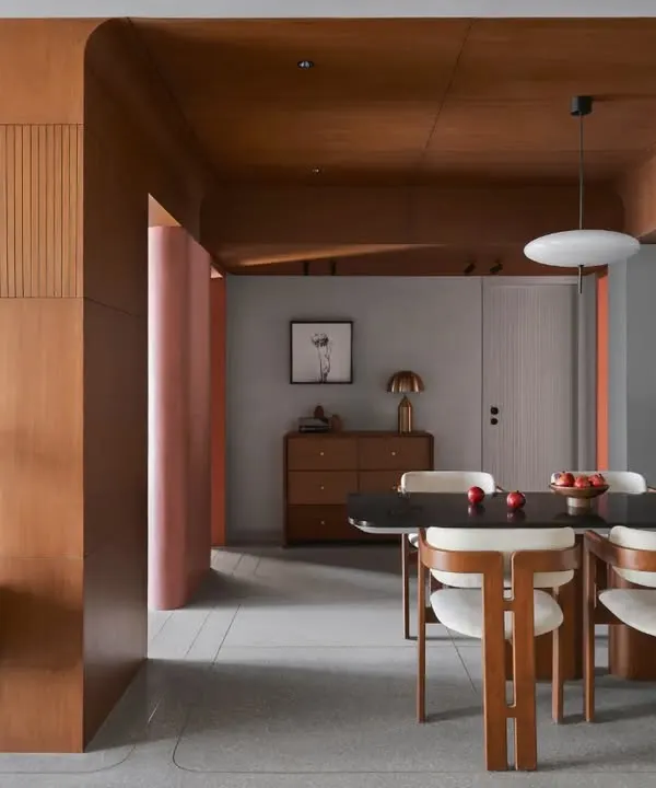 This dining area is designed as the apartment's centerpiece, featuring a wooden ceiling and Pamplona chairs. The space seamlessly connects different areas, fostering a sense of flow and continuity.