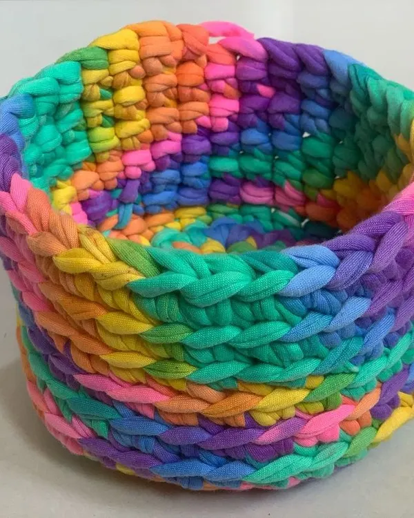 This colorful rainbow basket is made with a thick, chunky yarn, making it sturdy and durable. It's perfect for adding a pop of color and a bit of organization to your desk or dresser.