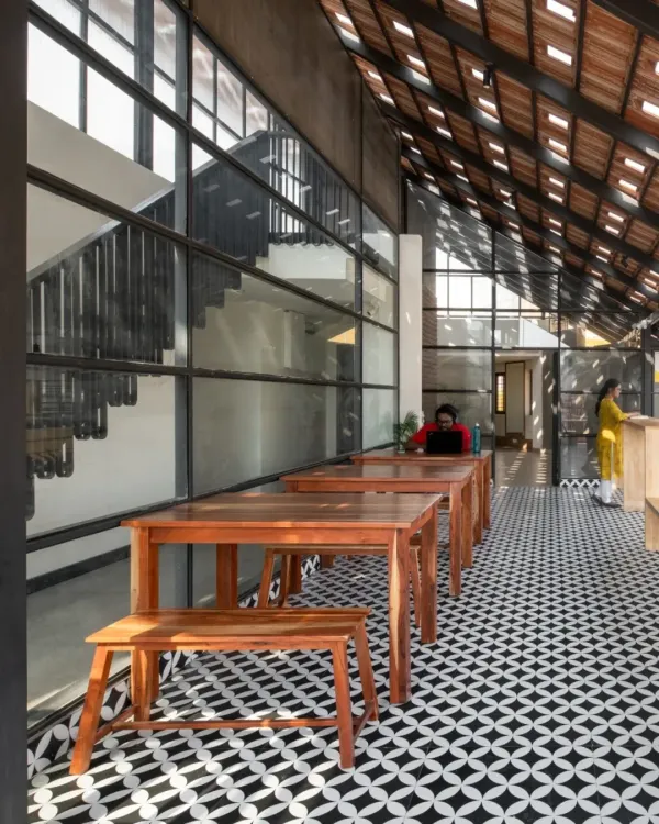 For the Earthen Spirit co-living project, I redesigned the terrace into an airy cafeteria and gym, featuring a Mangalore clay tile roof with glass inserts for dynamic light.