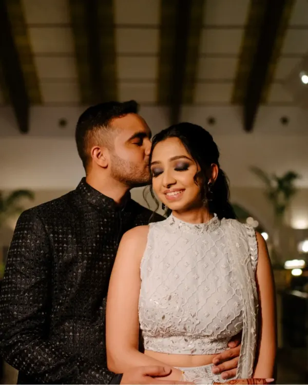 An intimate and romantic portrait of the groom kissing his bride's forehead during their Sangeet night, a quiet moment amidst the celebration.