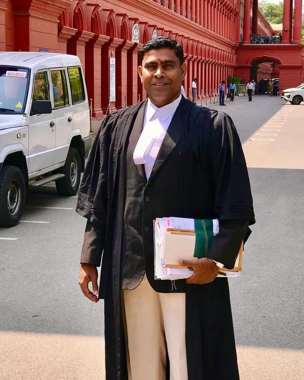 As an advocate with nearly two decades of experience, I am prepared to represent your property law case. Here I am outside the High Court of Karnataka, ready for a hearing.