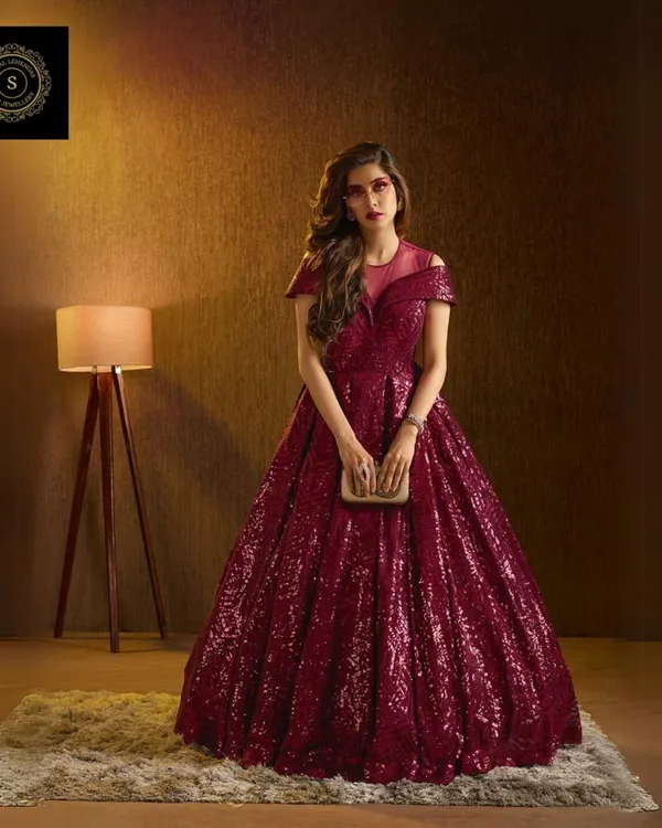 Steal the spotlight in this magnificent wine-colored sequin gown. The full, glittering skirt and flattering silhouette make it the perfect choice for a reception or gala event.