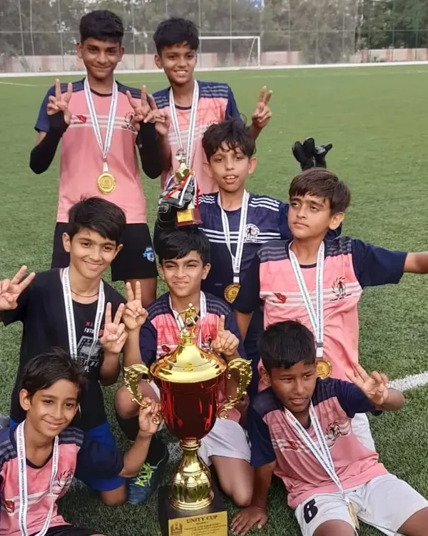 That winning feeling! Our players proudly lift the Unity Football Tournament trophy after a hard fought competition. This victory is a testament to their dedication.