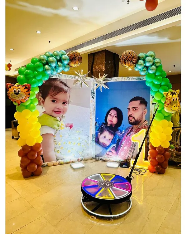 A clear view of the 360-degree video booth, set up in front of a personalized photo backdrop. It's a fantastic way for guests to capture fun, memorable videos.