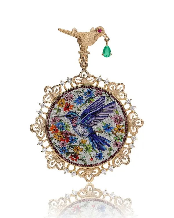 This hummingbird pendant captures a fleeting moment of beauty, handcrafted with a vibrant micromosaic set in 18k gold. It features a delicate bird bringing a gift of a Zambian emerald, symbolizing joy and resilience.