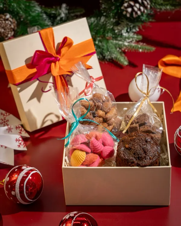 This is my Smol Christmas Hamper, packed with festive goodies like a mini boozy cake, almond marzipan, and cinnamon sugar kulkuls. It's the perfect edible gift, all wrapped up in a reusable box.