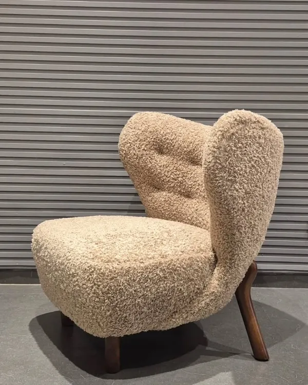 This is one of my favourite designs, a lounge chair upholstered in a beautiful bouclé fabric. The unique, sculptural form and solid wood legs make it a true statement piece for any living room or building lobby.