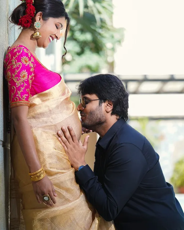 A close-up, colorful maternity portrait. The partner kissing the baby bump is a classic expression of love and excitement for their coming child.
