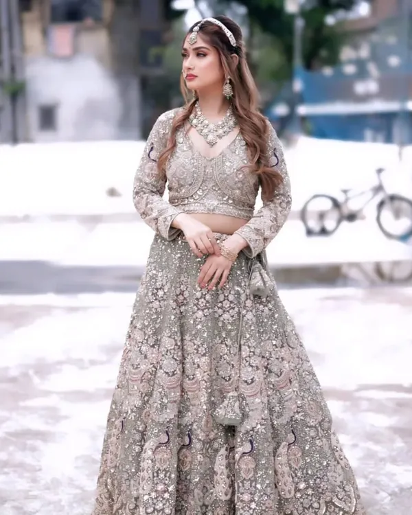 This heavily embroidered pastel green lehenga is a showstopper. The intricate peacock motifs and full-coverage sequin work make it a luxurious choice for a bride or bridesmaid.