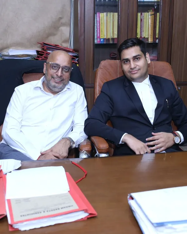 Seated in my chamber with a senior colleague, surrounded by case files. This is where we collaborate and plan the best course of action for complex legal matters.