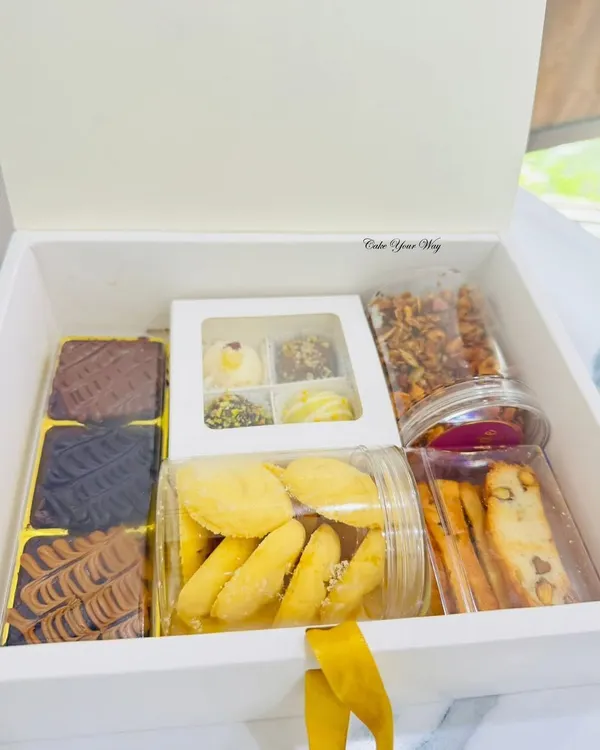 This is what a box of pure happiness looks like. My handcrafted hampers are packed with a variety of my best eggless bakes, including fudgy brownies, assorted truffles, crunchy biscotti, and fresh cookies. It's the perfect gift for any celebration.