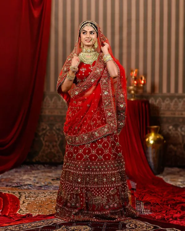 This magnificent red bridal lehenga, inspired by the film 'Padmavat', is a masterpiece of heavy embroidery and royal design. It's the perfect rental for a bride who wants to feel like royalty on her wedding day.