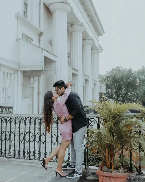A playful, romantic kiss set against the classic colonial architecture of Mumbai's Town Hall, showcasing how we can use the city's landmarks for beautiful couple portraits.