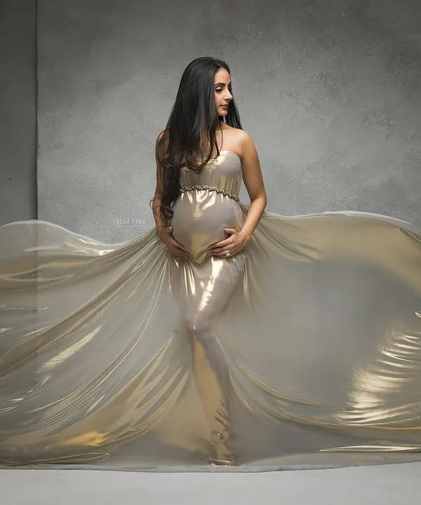 A river of gold. This is one of my signature fine-art maternity portraits, using flowing metallic fabric and dramatic lighting to create a breathtaking, goddess-like image.