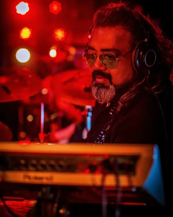 Our keyboardist, deep in the zone, surrounded by the warm glow of the stage lights.
