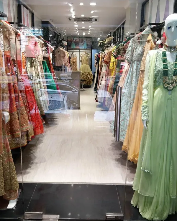 A view from the entrance of my store, showcasing mannequins dressed in the latest styles and racks of colorful designer wear waiting to be explored.
