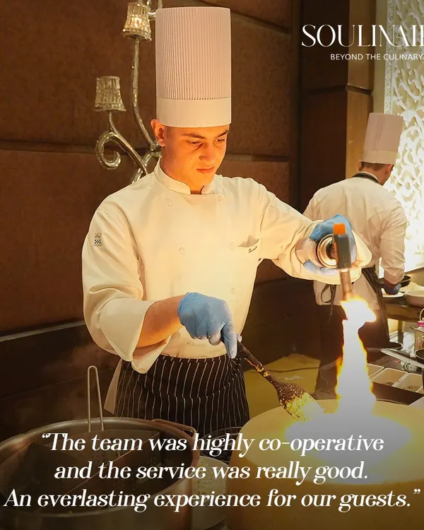 A chef uses a blowtorch to add the finishing touch to a dish, creating a dramatic flair at a live station. This is where flavour meets finesse and food becomes a performance.
