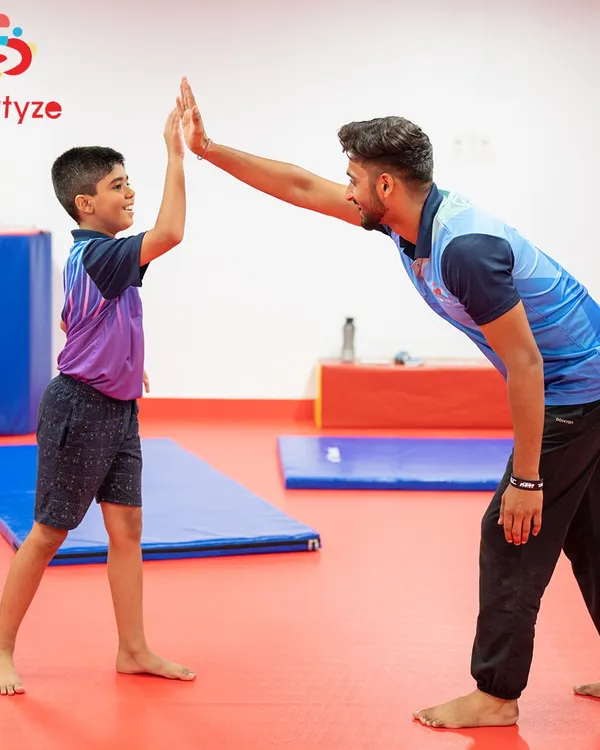 A high five for a job well done. Our coaches celebrate every small win, providing constant encouragement and positive reinforcement to build confidence alongside physical strength in our young gymnasts.