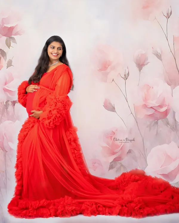 This breathtaking portrait in a flowing red gown against a floral backdrop captures the essence of our glamorous and artistic style. We aim to make every mother-to-be feel like a queen.
