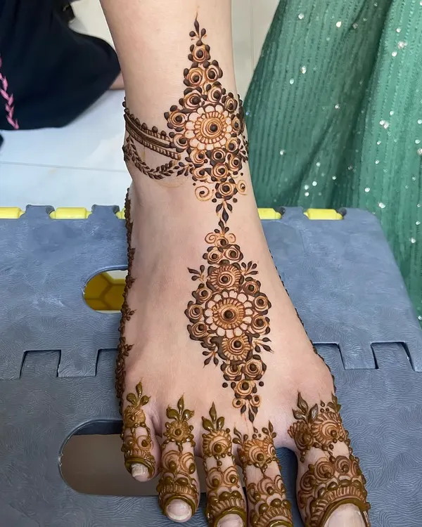 A delicate and beautiful foot design, featuring a central vine with mandalas and detailed toe patterns.
